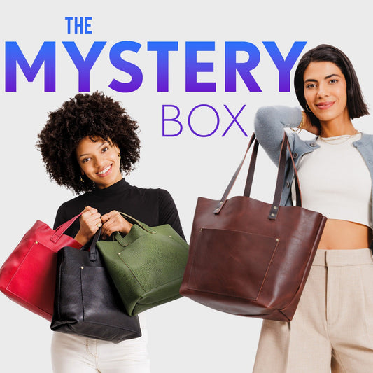 Two women holding Medium Crossbodies and Leather Tote Bags  with 'The Mystery Box' text in the background