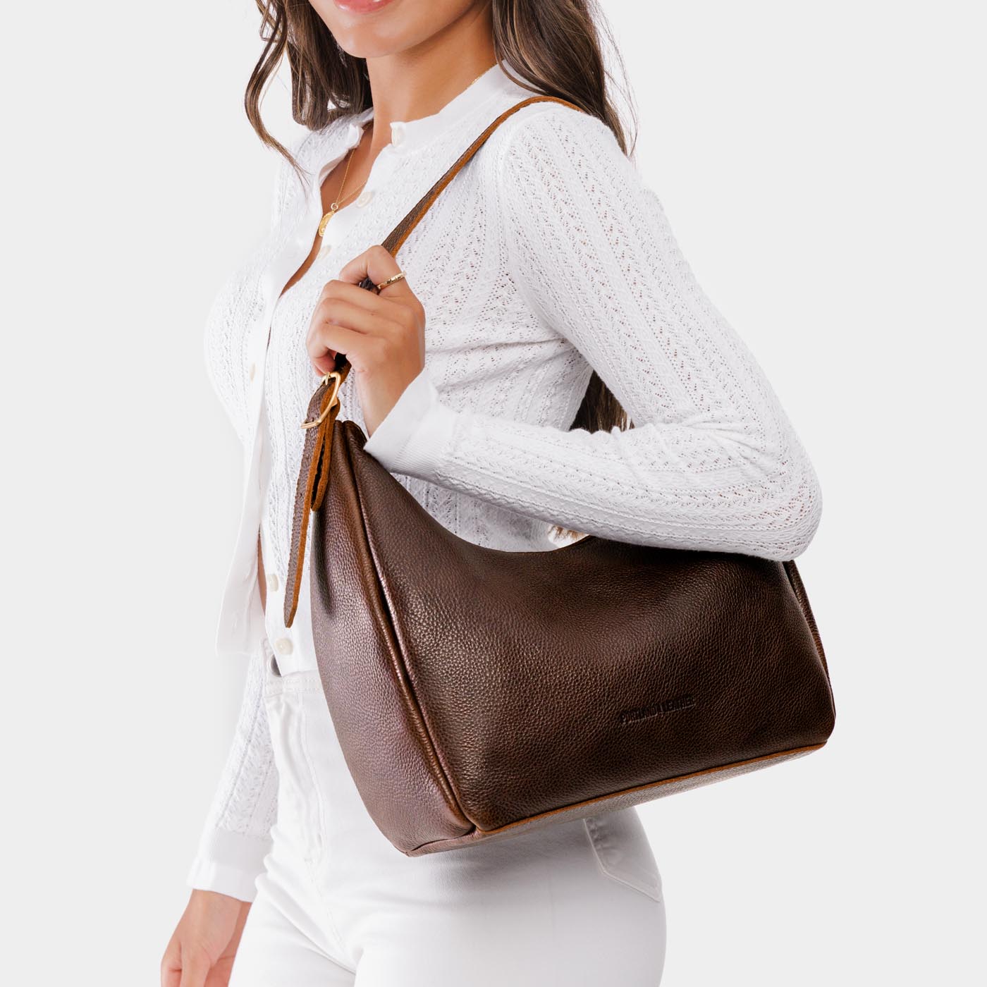 Coldbrew*Medium | Model holding u-shaped, flat-bottomed leather shoulder bag with adjustable strap