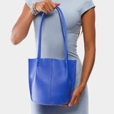 Astro Blue Classic | Model holding petite bucket shaped tote bag with matching leather handles