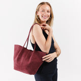 Red Panda Large | Model holding wide bucket shaped tote bag with matching leather handles