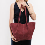 Red Panda Large | Model holding wide bucket shaped tote bag with matching leather handles
