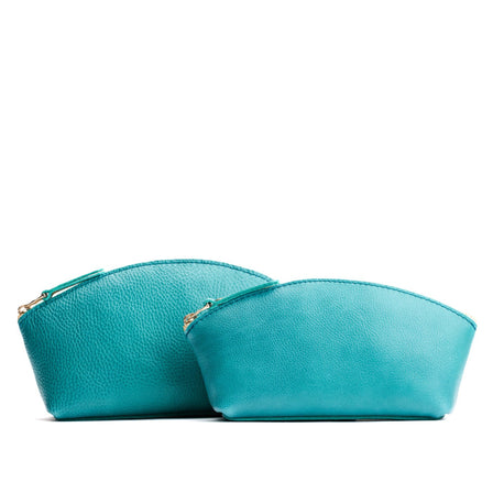 Seafoam | Size comparison shot of two spacious leather makeup bags with curved seams and top zipper