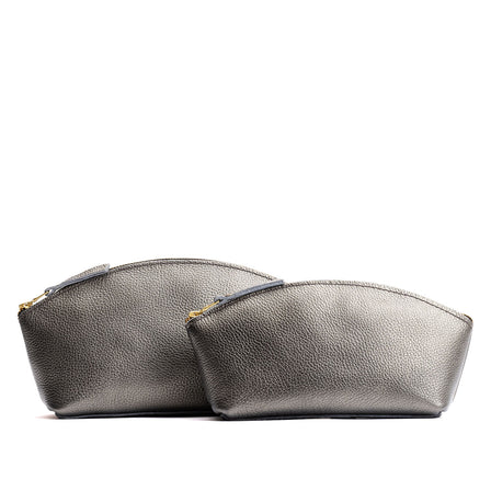 Stardust | Size comparison shot of two spacious leather makeup bags with curved seams and top zipper