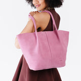 Pink Suede Oversized | Model holding extra wide bucket shaped tote bag with matching leather handles