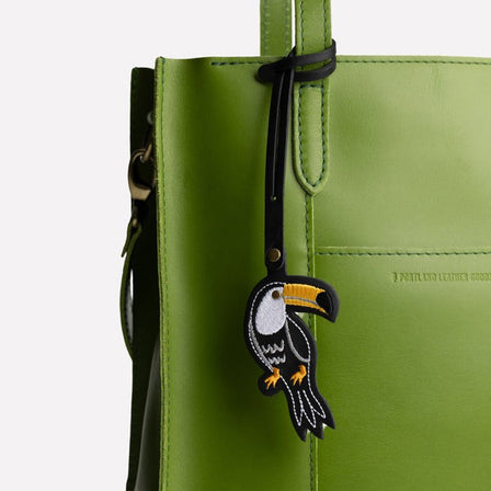Toucan | Toucan embroidered on a black leather tassel on a white background