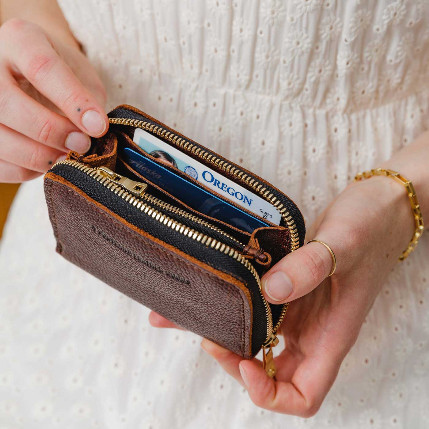 Coldbrew | Model holding small leather wallet with zipper