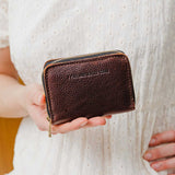 Coldbrew | Model holding small leather wallet with zipper