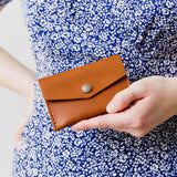 Honey | Model holding small leather envelope wallet with snap closure